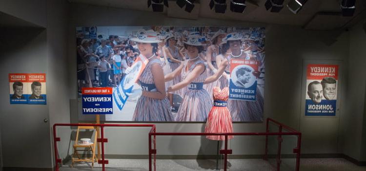 a display with a photo 和 one of jackie kennedy's dresses at the JFK presidential library 和 museum